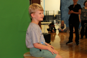  student posing for photo in front of a green screen